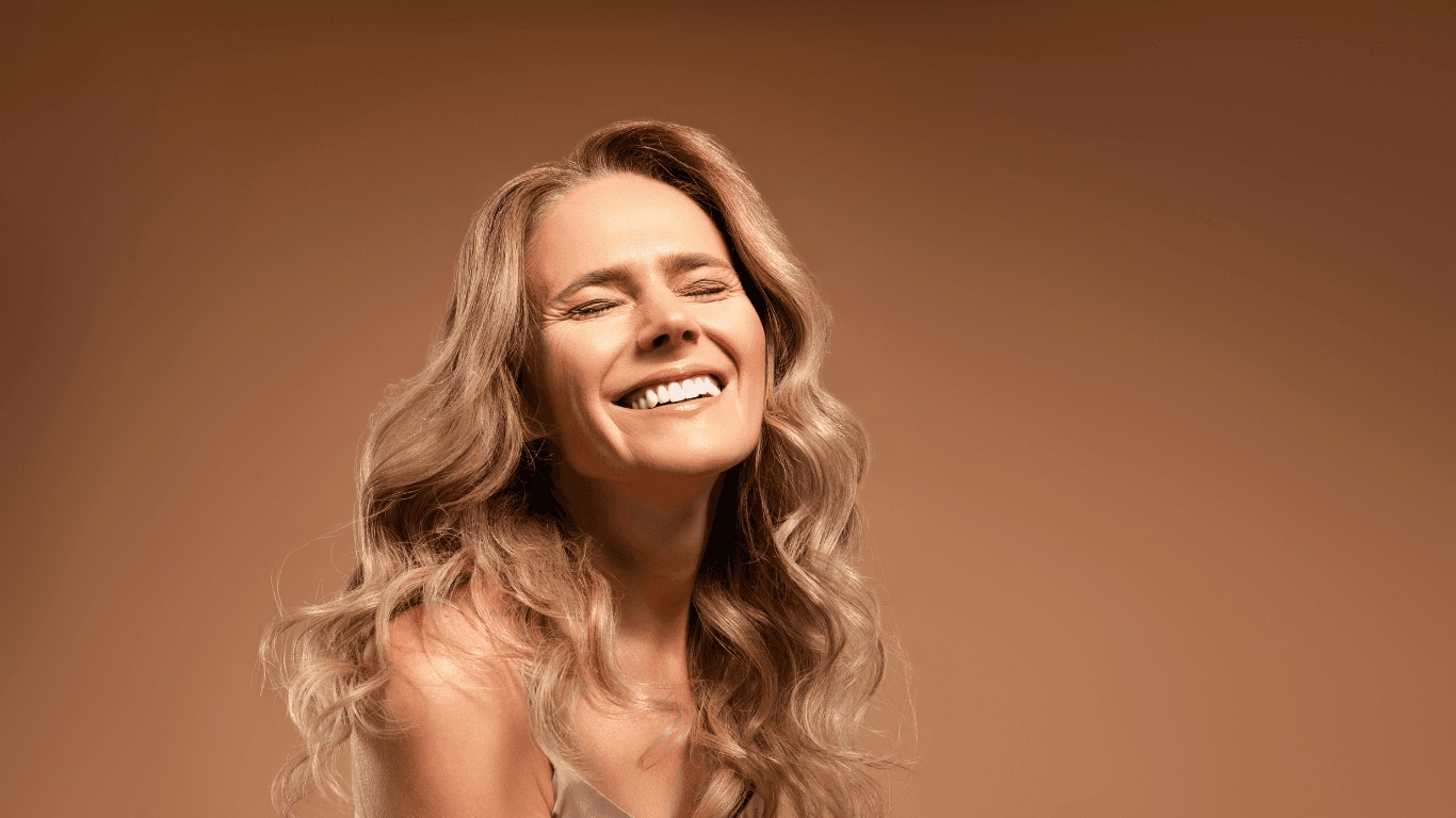 Smiling woman with soft, golden balayage waves – featured image for Cruz Hairworks blog post comparing balayage and highlights in Whitley Bay.