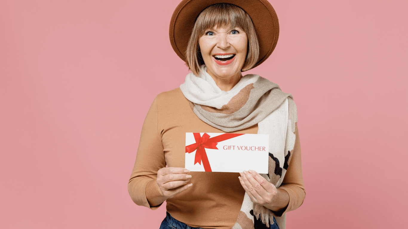 Smiling woman holding a gift voucher with a red bow – promoting Cruz Hairworks salon gift cards available in Whitley Bay.
