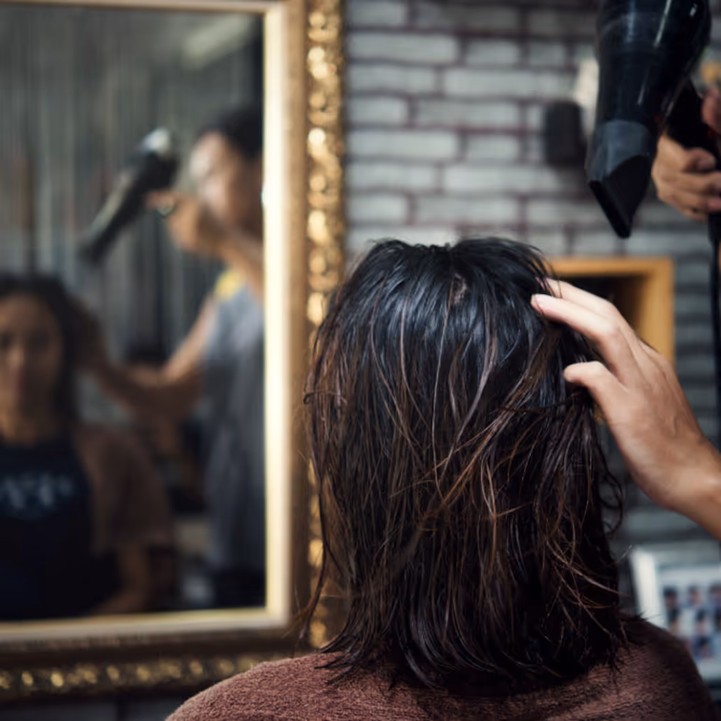 Client receiving a professional haircut and blow-dry at Cruz Hairworks, Whitley Bay – expert cutting and styling in a calm, elegant salon setting.