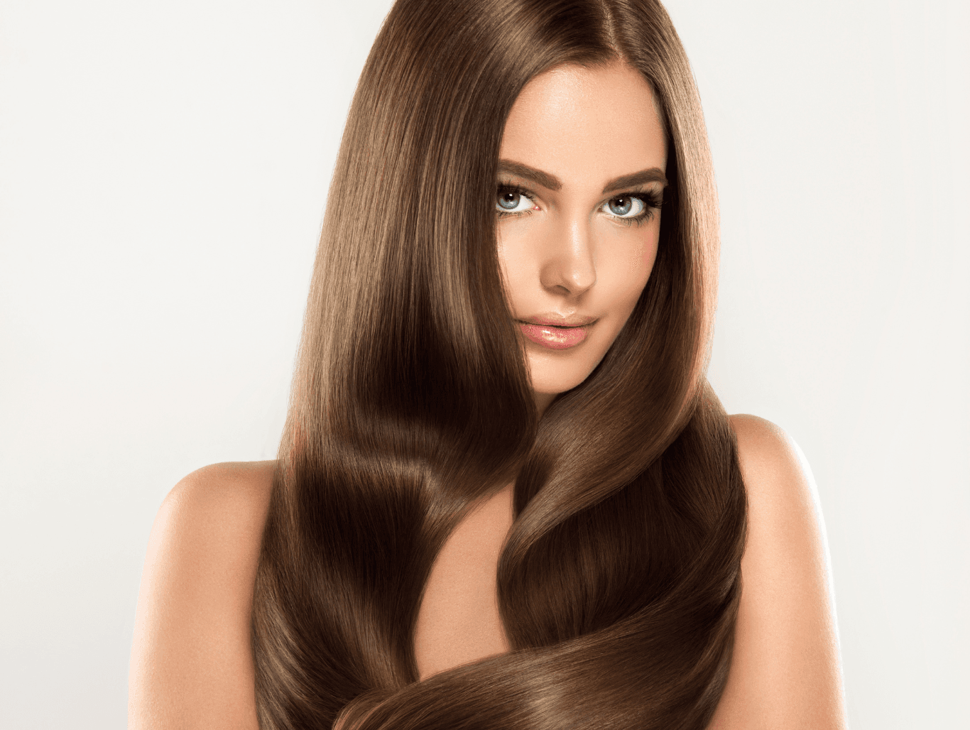 Woman with long, silky brunette hair finished with a full head tint for rich, even colour at Cruz Hairworks