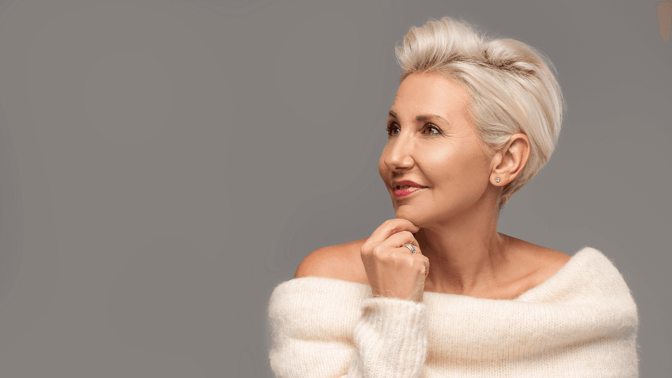 Smiling woman with a short, styled blonde haircut wearing a soft cream jumper – showcasing a professional cut and blow-dry for shorter hair at Cruz Hairworks in Whitley Bay.