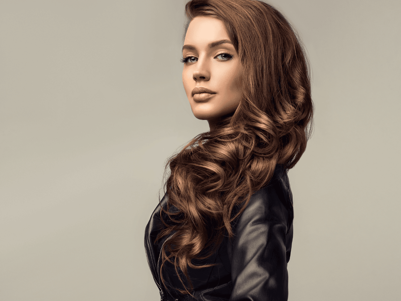 Woman with long, voluminous brunette curls styled after a professional shampoo and blowdry at Cruz Hairworks