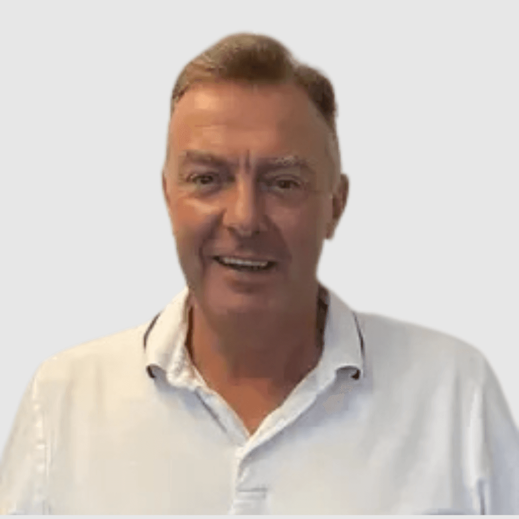 Mark Murray, Salon Owner at Cruz Hairworks in Whitley Bay, wearing a white polo shirt and smiling at the camera.