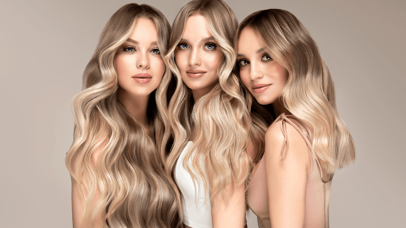 Three women with bright, blended blonde highlights and long, styled hair – showcasing professional colour services at Cruz Hairworks in Whitley Bay.