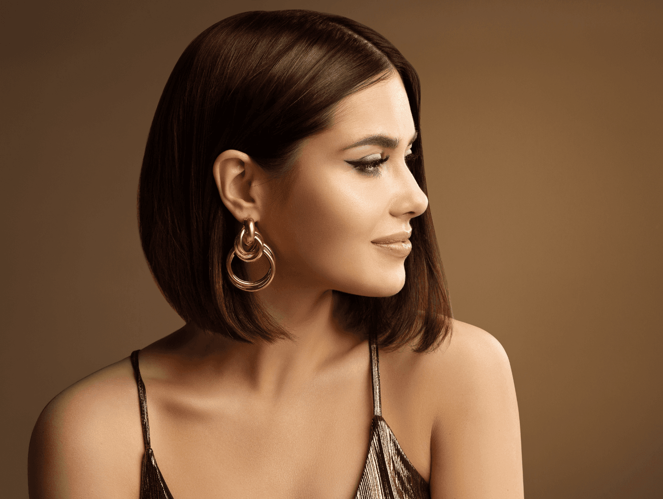 Woman with sleek, rich brunette hair showing seamless colour from a professional regrowth tint at Cruz Hairworks
