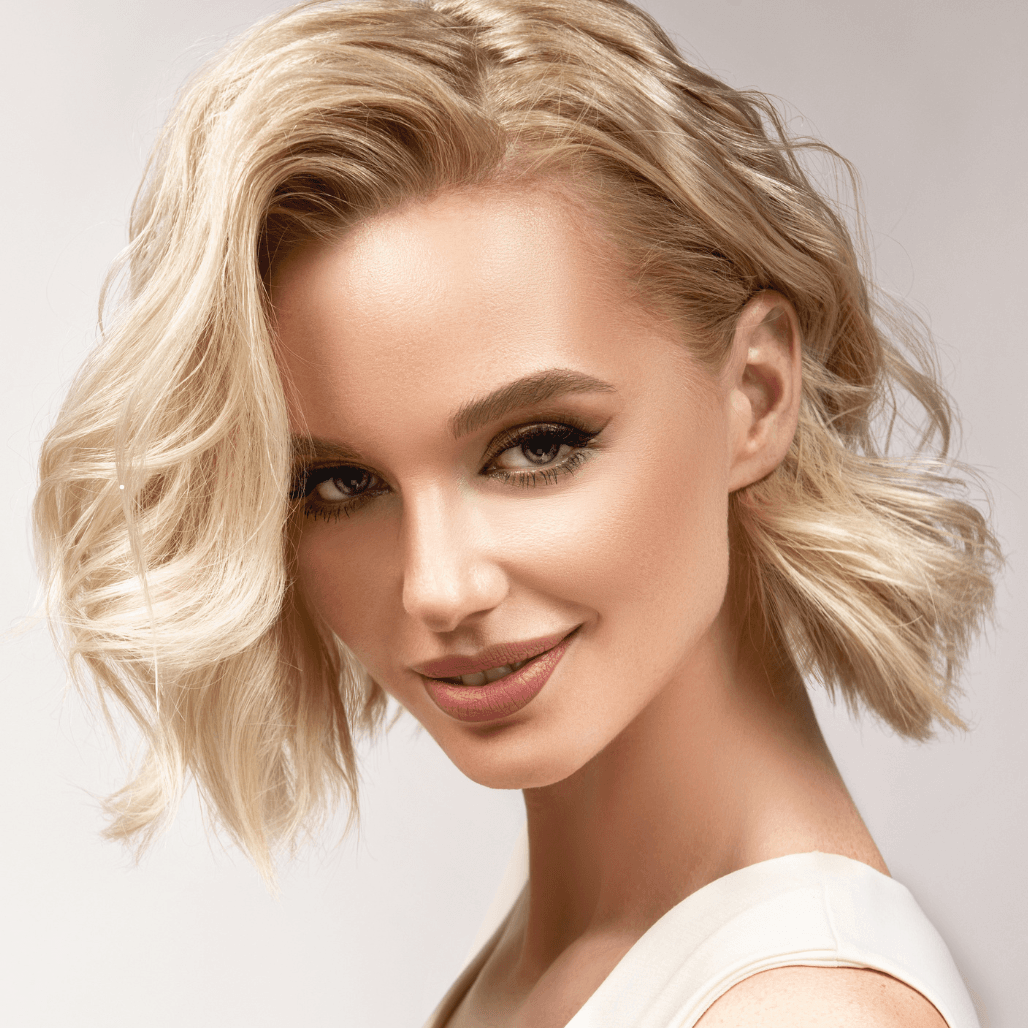 Woman with soft blonde waves and a polished finish – showcasing professional hair colouring and styling at Cruz Hairworks in Whitley Bay.